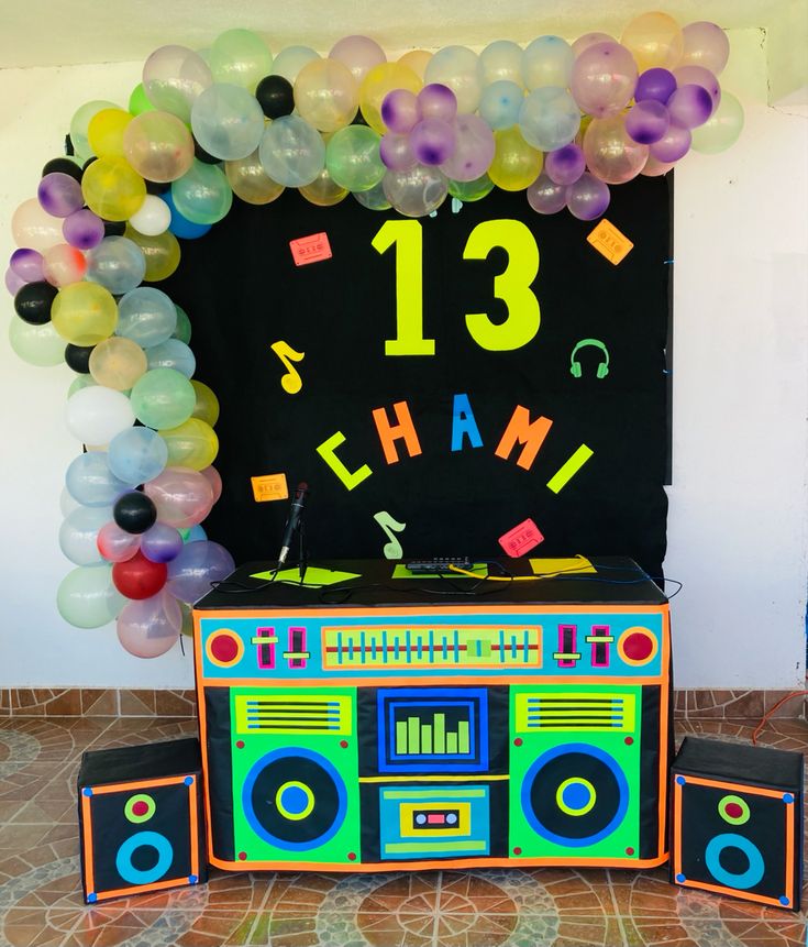 an old school boombox decorated with balloons and streamers for a 13th birthday party