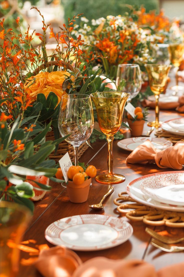 the table is set with oranges and wine glasses for an elegant dinner party or celebration