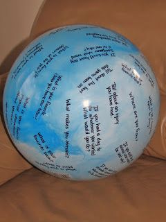 a blue and white ball sitting on top of a brown couch next to a pillow