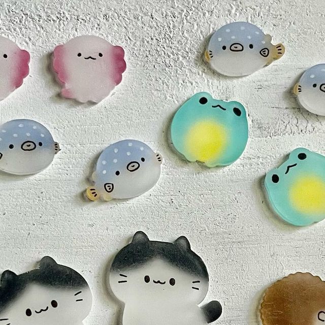 there are many different kinds of buttons on the wall with cats and fish in them