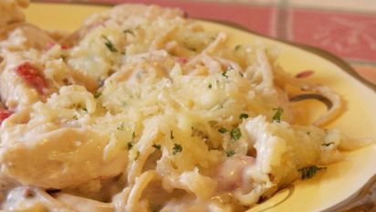 a yellow plate topped with pasta and meat covered in grated parmesan cheese