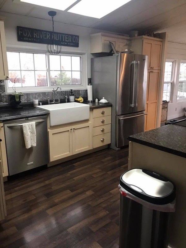 a kitchen with wooden floors and stainless steel appliances in the middle of it is shown