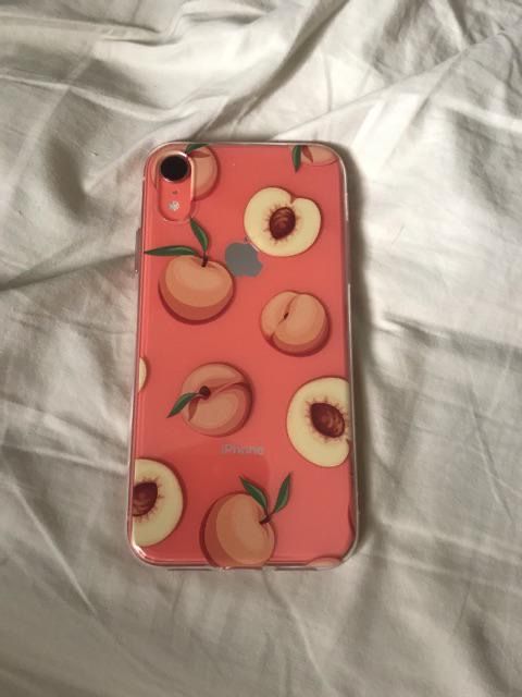 an iphone case with peaches on it sitting on a white sheet covered bedding