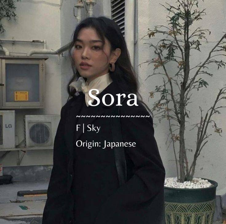 a woman standing in front of a building with the words sora written on it