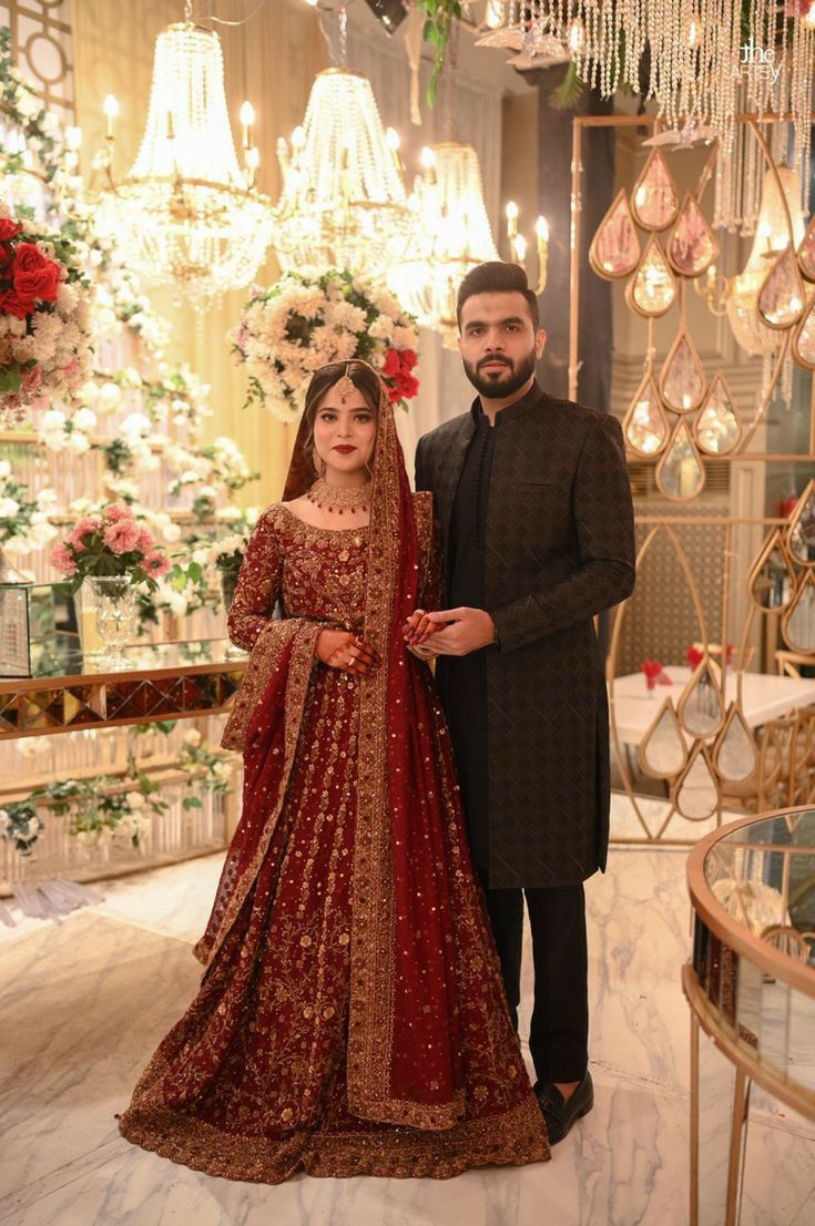 the bride and groom pose for a photo in front of chandeliers