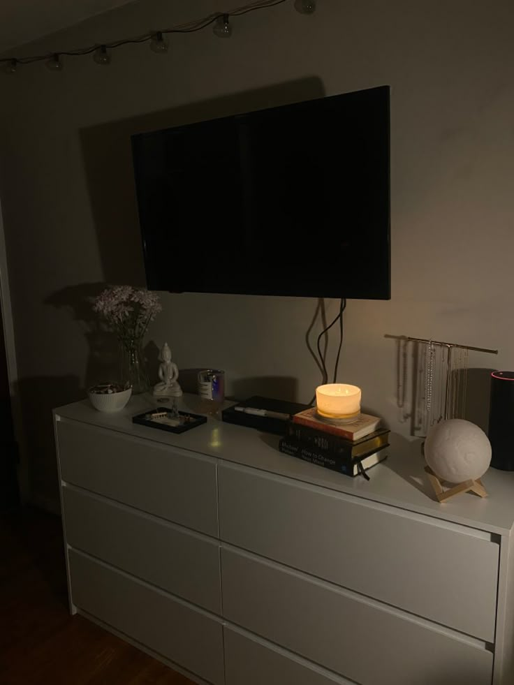 a flat screen tv sitting on top of a white dresser