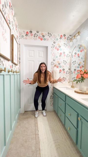 a woman is standing in the bathroom with her hands out and arms spread wide open