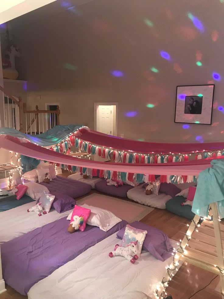 there are many beds with lights on them in the room and one bed is made up to look like a hammock