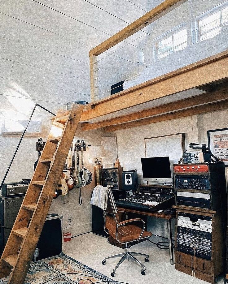 a room with a ladder, computer desk and other musical equipment on the floor in front of it