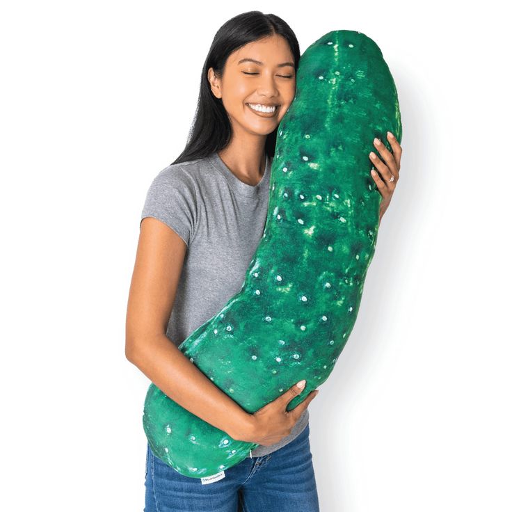 a woman is hugging a large green pillow