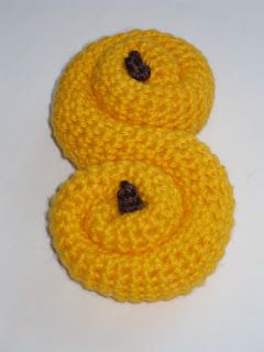 two crocheted yellow buttons on a white surface