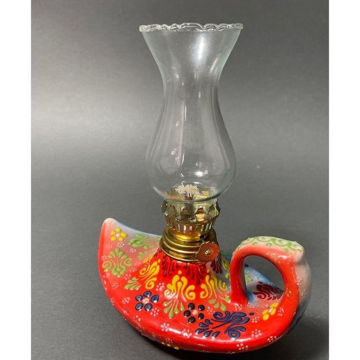 a red and yellow pipe with a glass vase on top