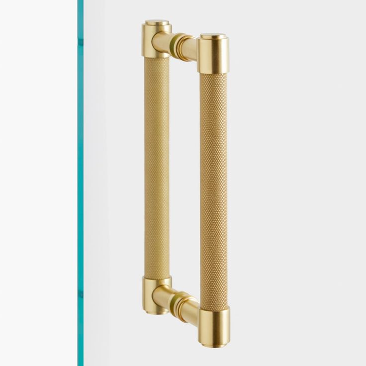 an image of two handles on a door with the handle in gold and the other in white