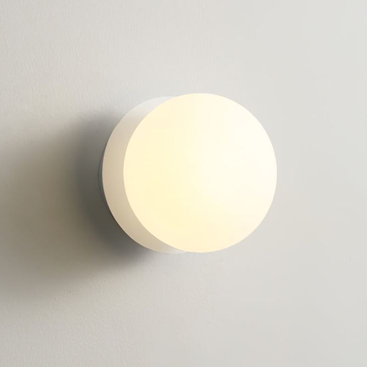 a white light is on the wall next to a gray wall