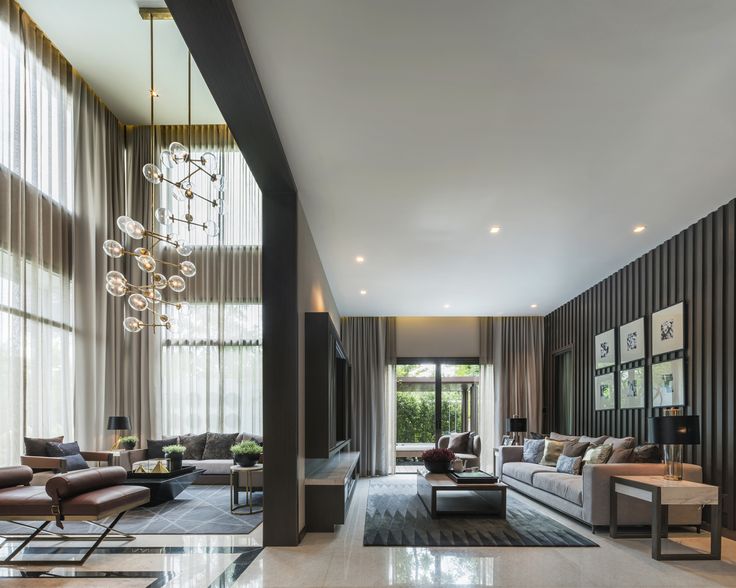 a large living room with couches, chairs and chandelier hanging from the ceiling