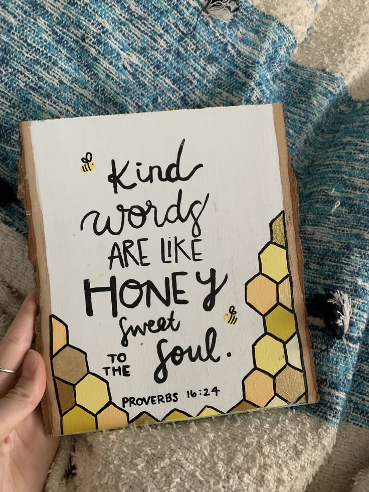 someone holding up a book with the words, kind words are like honey to the soul