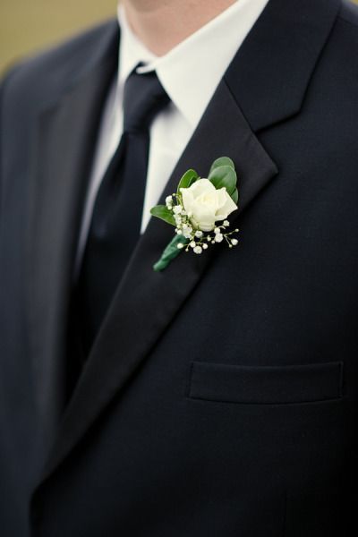 a man in a suit and tie with a boutonniere on his lapel