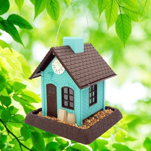 a blue birdhouse hanging from a tree branch