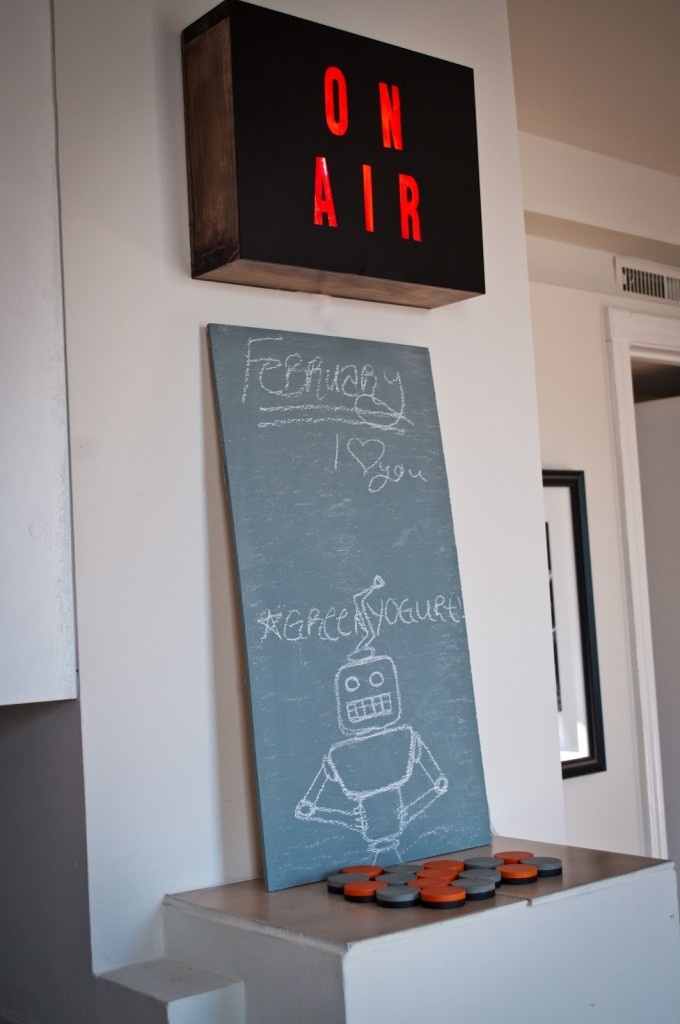 a sign that says on air and an image of a robot drawn on the board