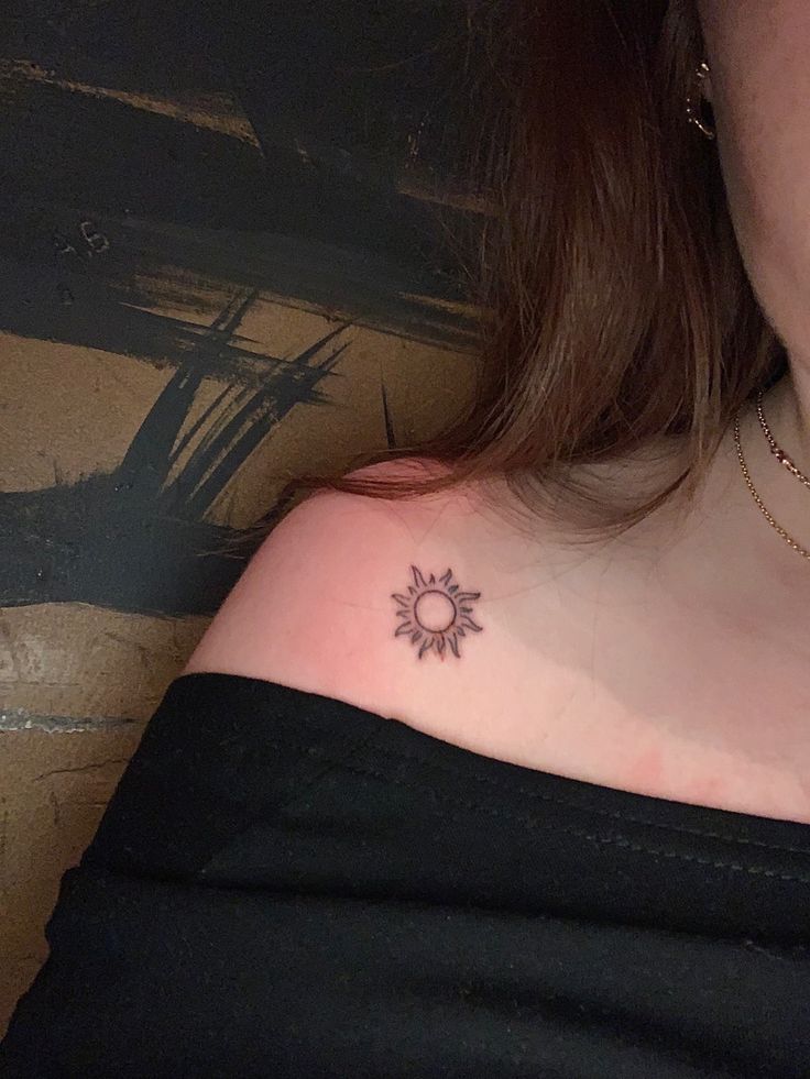 a woman with a small sun tattoo on her chest