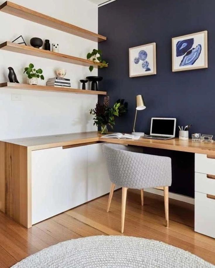 a desk with a laptop on it in a room that is painted blue and white