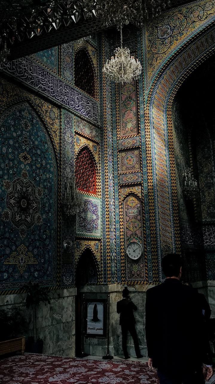 a man standing in front of a colorfully decorated room with chandelier hanging from the ceiling