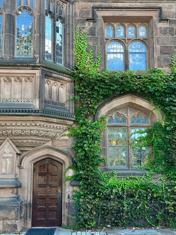 an old building with ivy growing on it's side and a wooden door in front