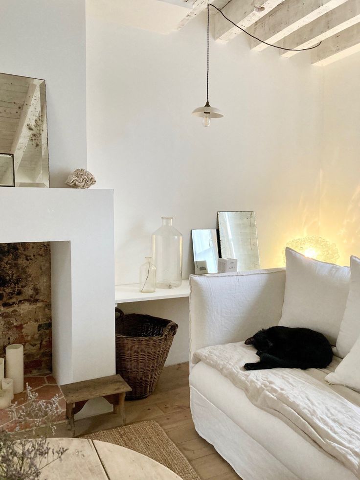 a living room filled with furniture and a fire place next to a white fireplace covered in candles