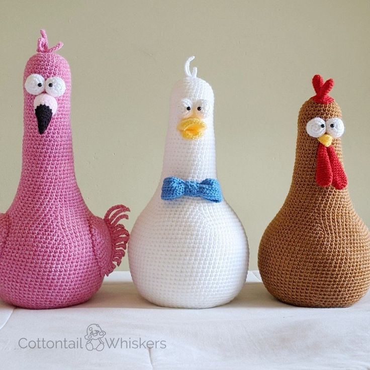 three crocheted chickens sitting next to each other on top of a white table