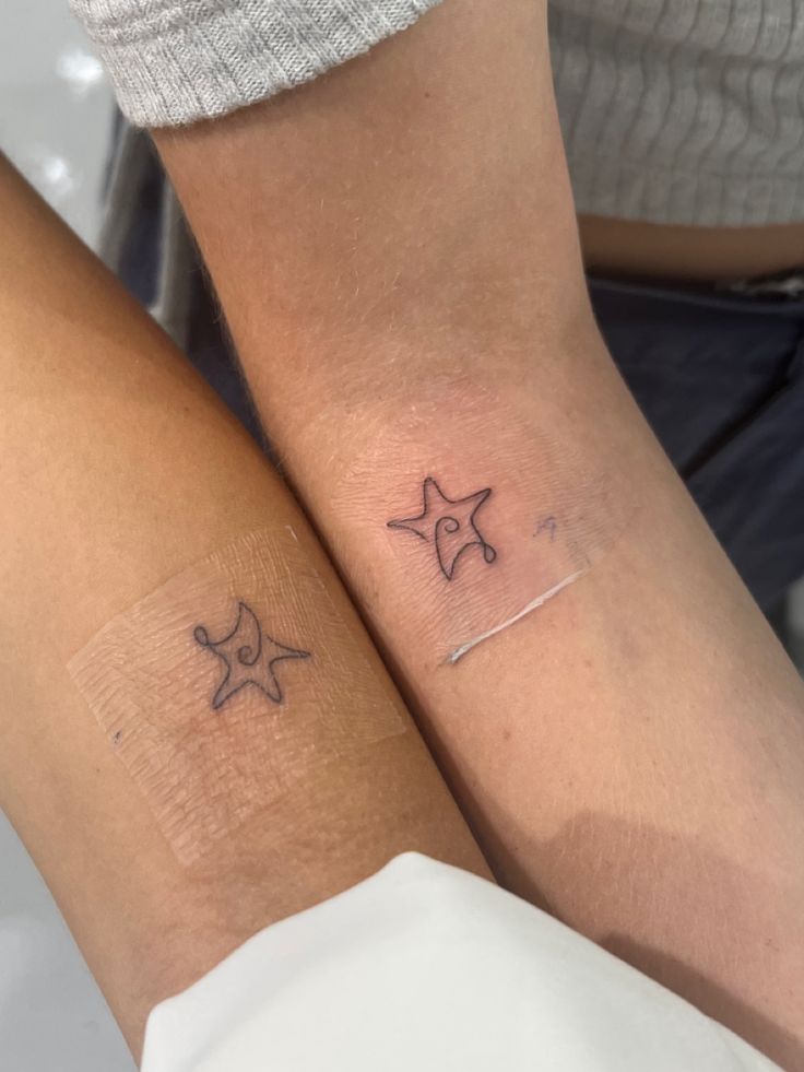 two people with matching tattoos on their arms