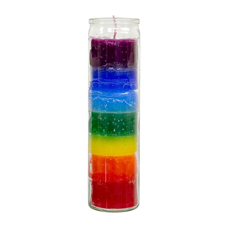 a multicolored candle is in a glass vase