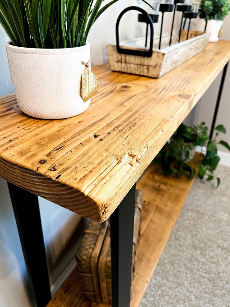 a potted plant sitting on top of a wooden table next to a shelf filled with plants