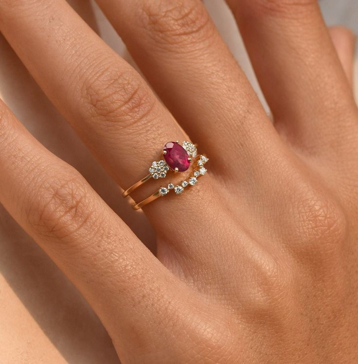 a woman's hand with a gold ring and diamond set on it, showing the middle finger