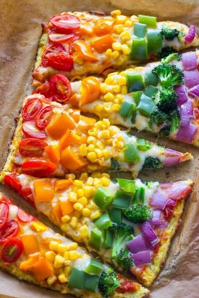 a pizza with many different toppings on it sitting on top of a piece of parchment paper