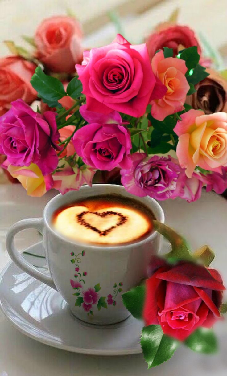 a cup of cappuccino with a heart drawn on it and flowers in the background