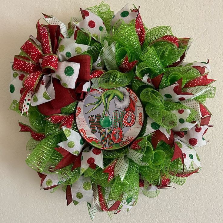 a green and red christmas wreath with the word joy on it's center piece