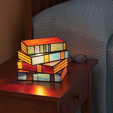 a stained glass lamp sitting on top of a wooden table next to a blue couch