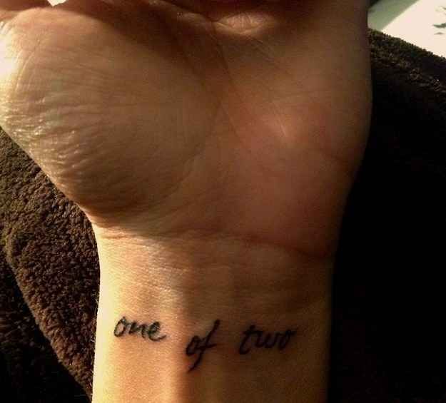 a person with a tattoo on their wrist that says one of them