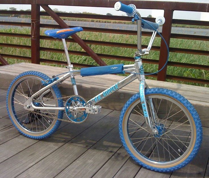 a blue and silver bike sitting on top of a wooden deck