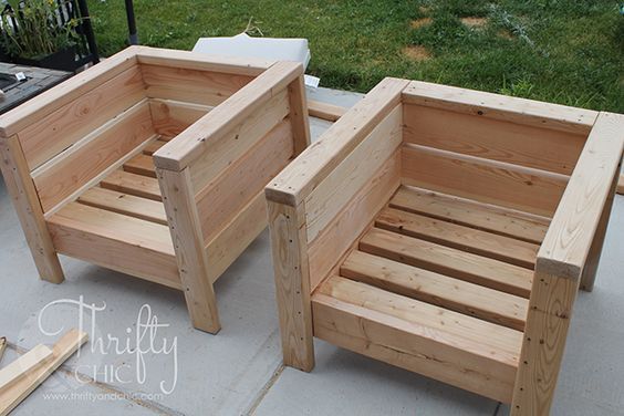 two wooden benches sitting next to each other on a cement floor in front of grass