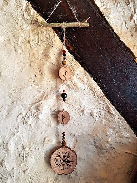 a wooden wind chime hanging on a wall next to a piece of wood and beads