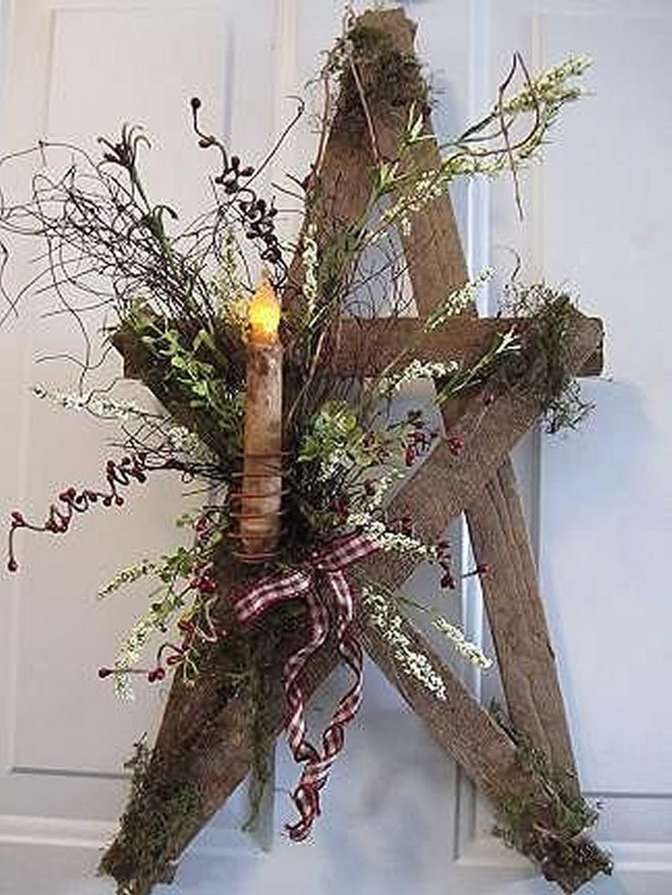 a star shaped wreath with greenery and a lit candle hanging on the front door