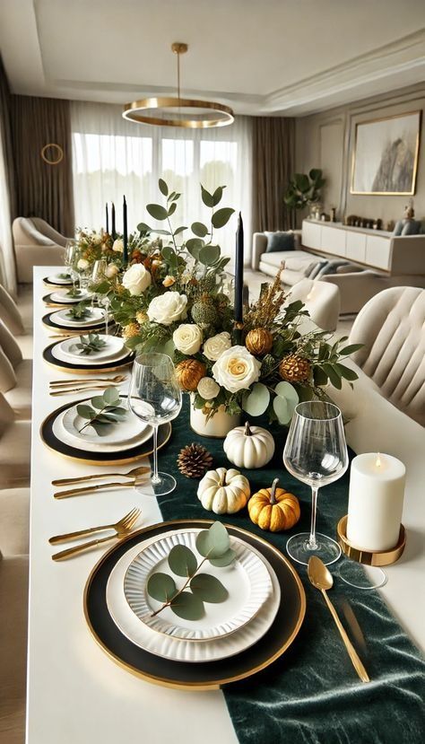 a dining room table is set with white and green plates, gold rimmed glasses, greenery and candles