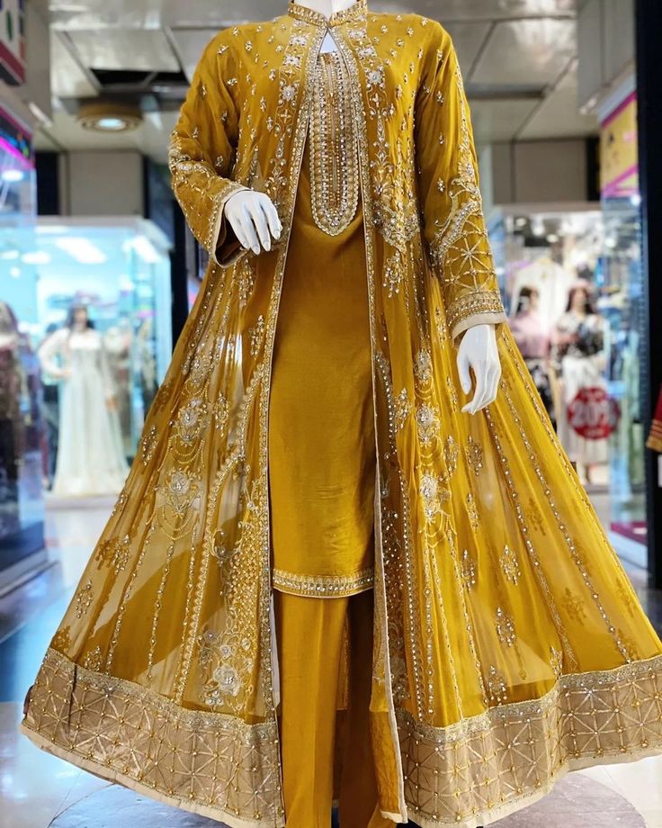 a mannequin dressed in a yellow outfit with gold trim and sequins