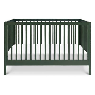 a green crib with white sheets on the bottom and side rails, in front of a