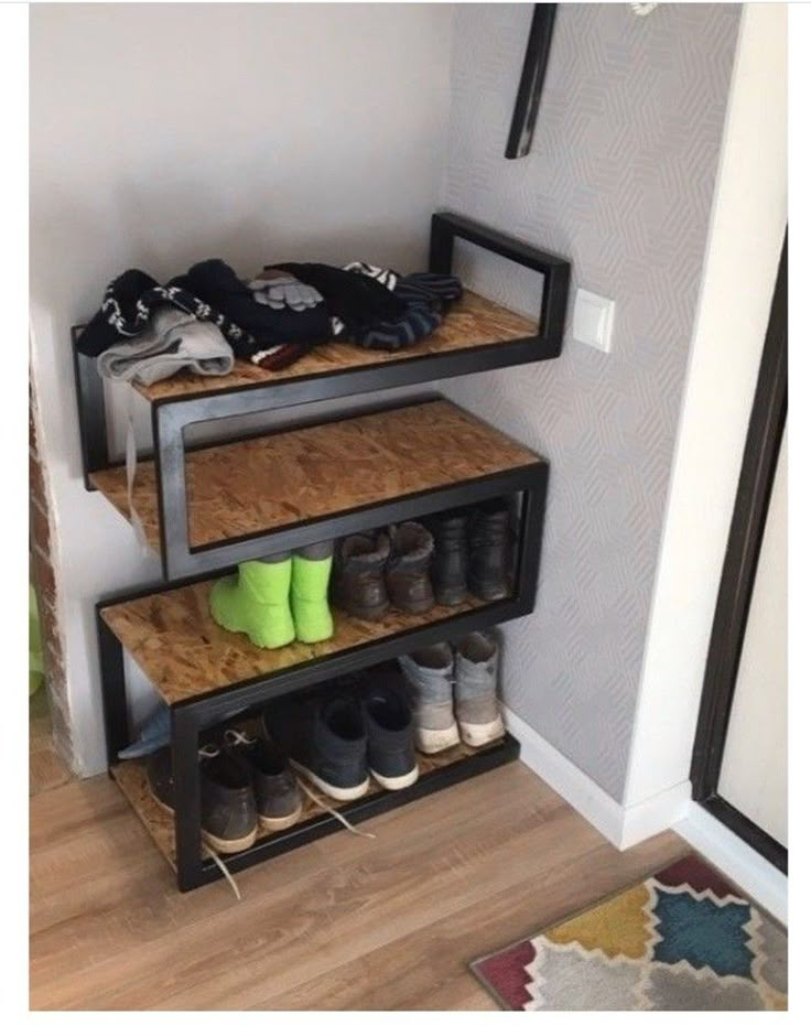 three shelves with shoes on them in the corner