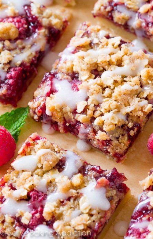 raspberry crumble bars with white icing and fresh raspberries on top