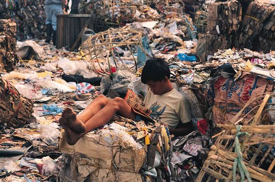 a man sitting on top of a pile of trash