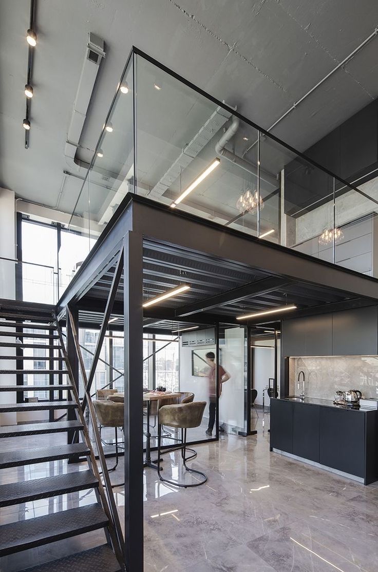 an open floor plan with stairs leading up to the kitchen and living room area in this modern loft apartment