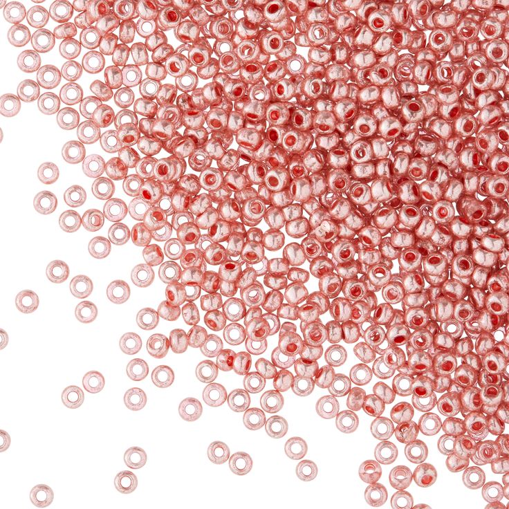 pink beads are scattered on a white surface